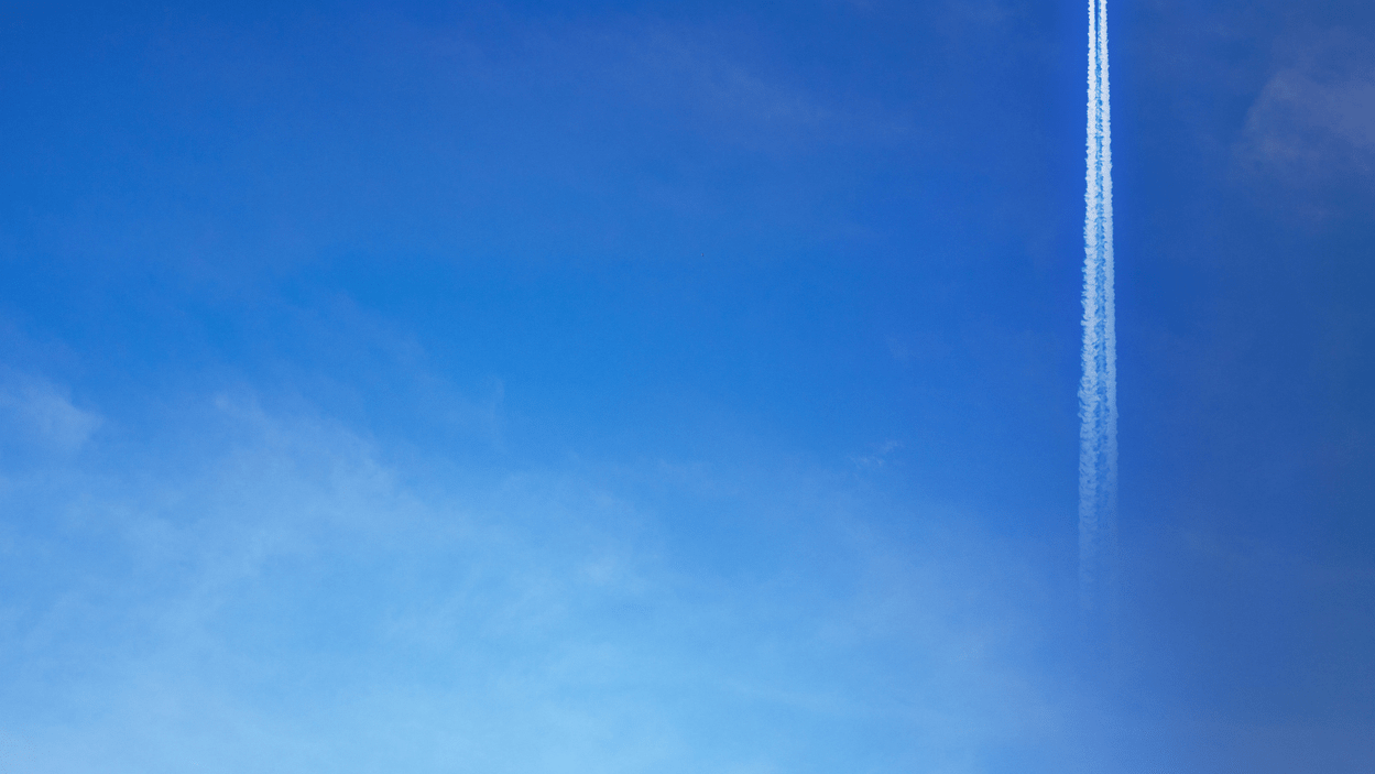 Blå himmel med røykspor fra fly.